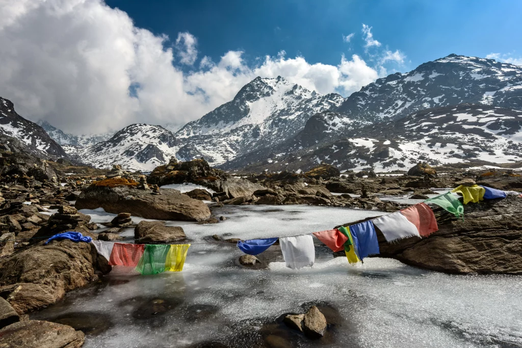 gosaikunda lake and flags on a rope in a snowy mountain